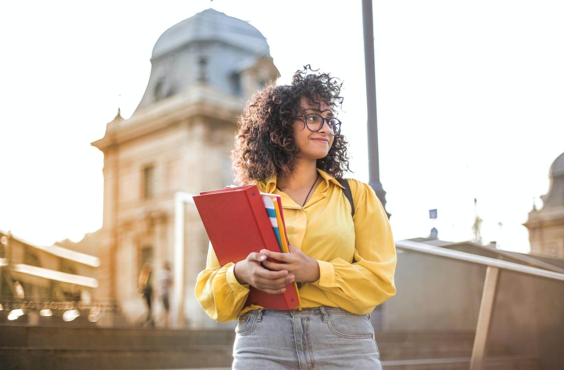 Woman In Yellow Jacket Holding Books