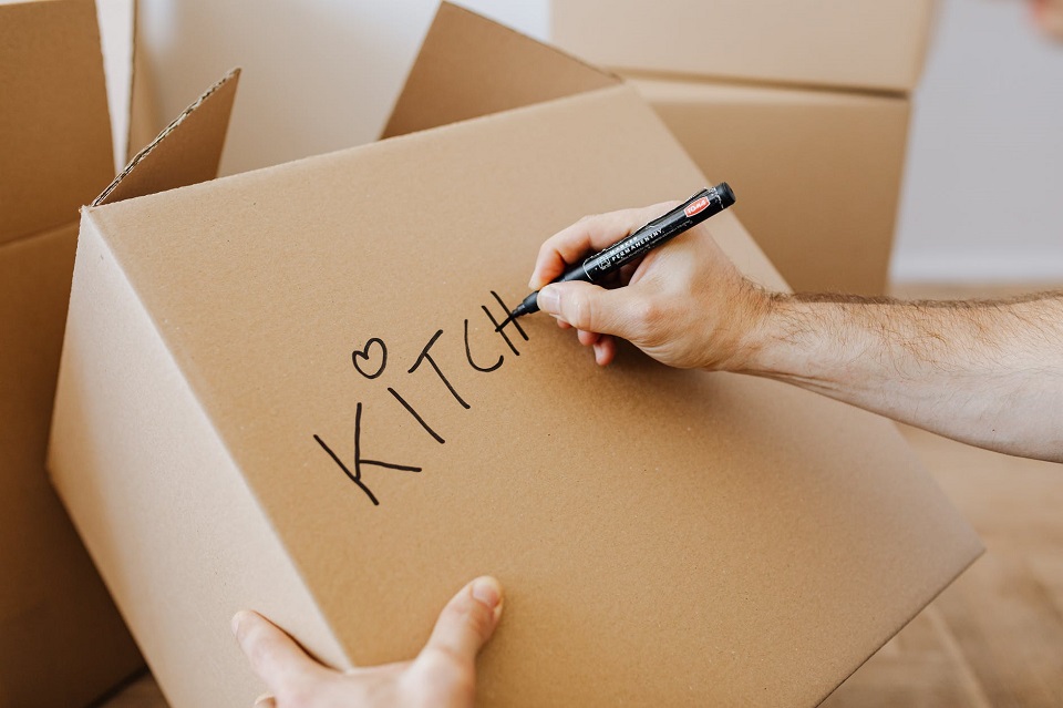 Crop man signing carton moving boxes