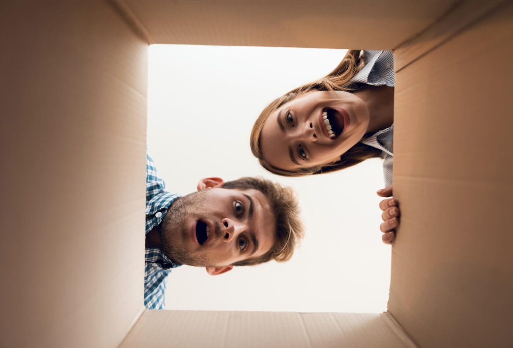 The girl and the boy are looking at the empty box. View from inside the box close-up.