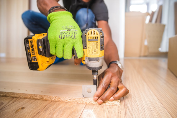 Person using cordless drill to assemble furntiure