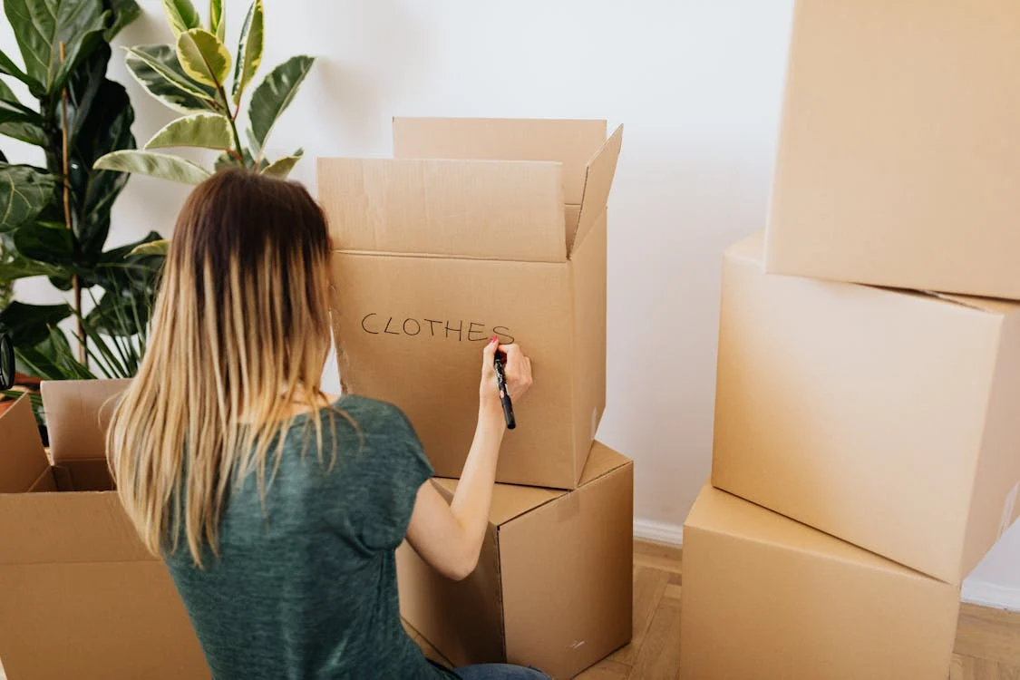 woman labelling moving box