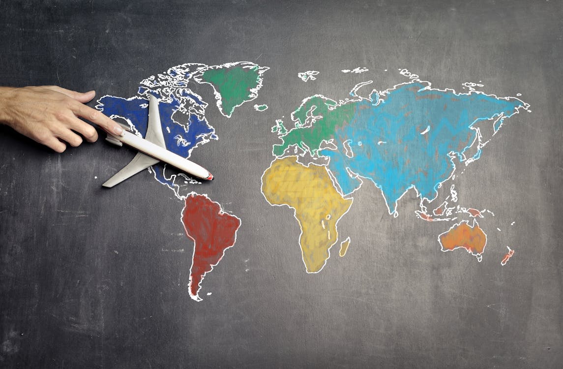 hand moving toy plane on hand drawn world map